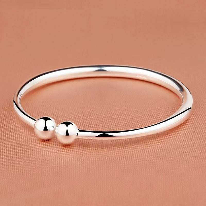 Open bangle in polished silver-tone copper with a smooth surface and two round bead ends, Garlic-head Plain Surface design