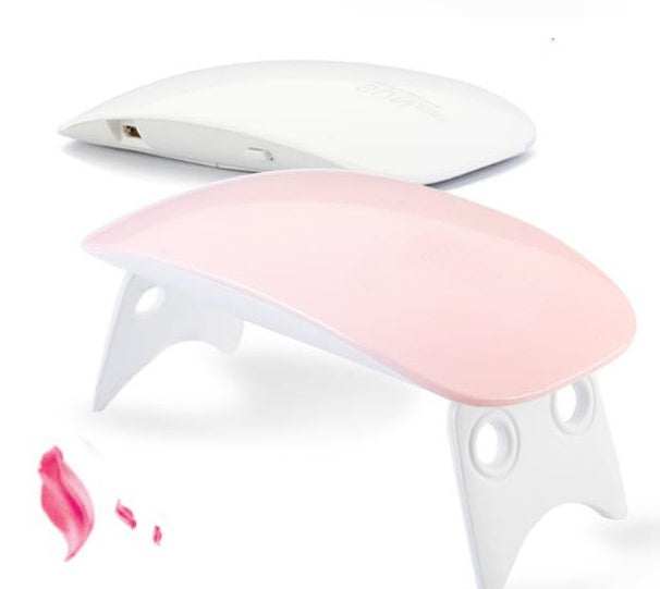 Light Therapy Machine in white and pale pink ABS, compact curved design with fold-out legs and USB port