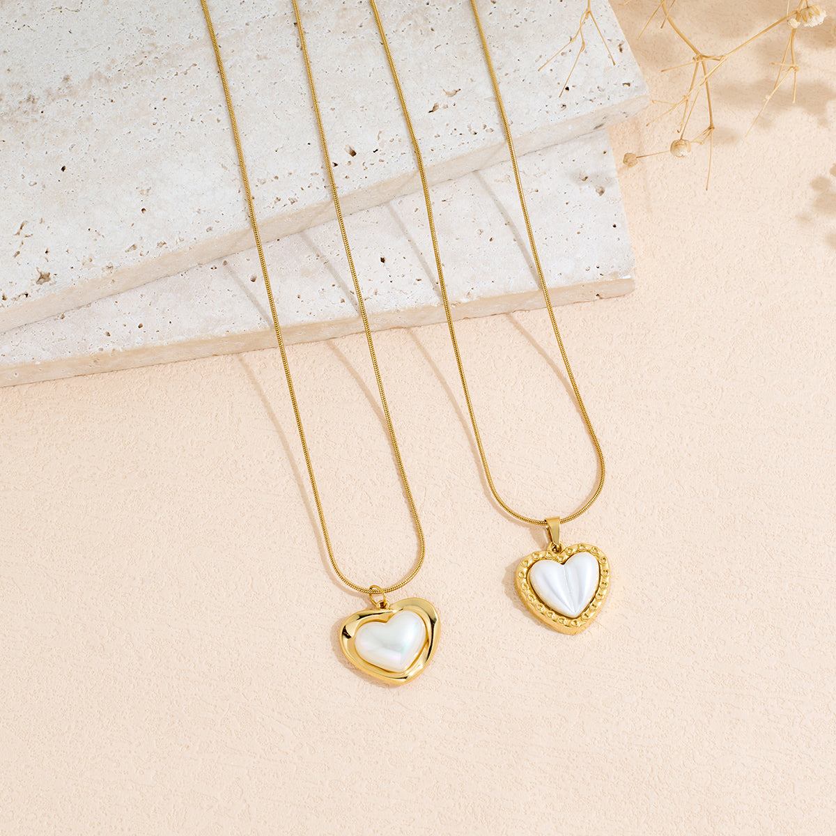 Stainless Steel heart-shaped pendant necklace with polished gold-tone chains and white heart inlays.