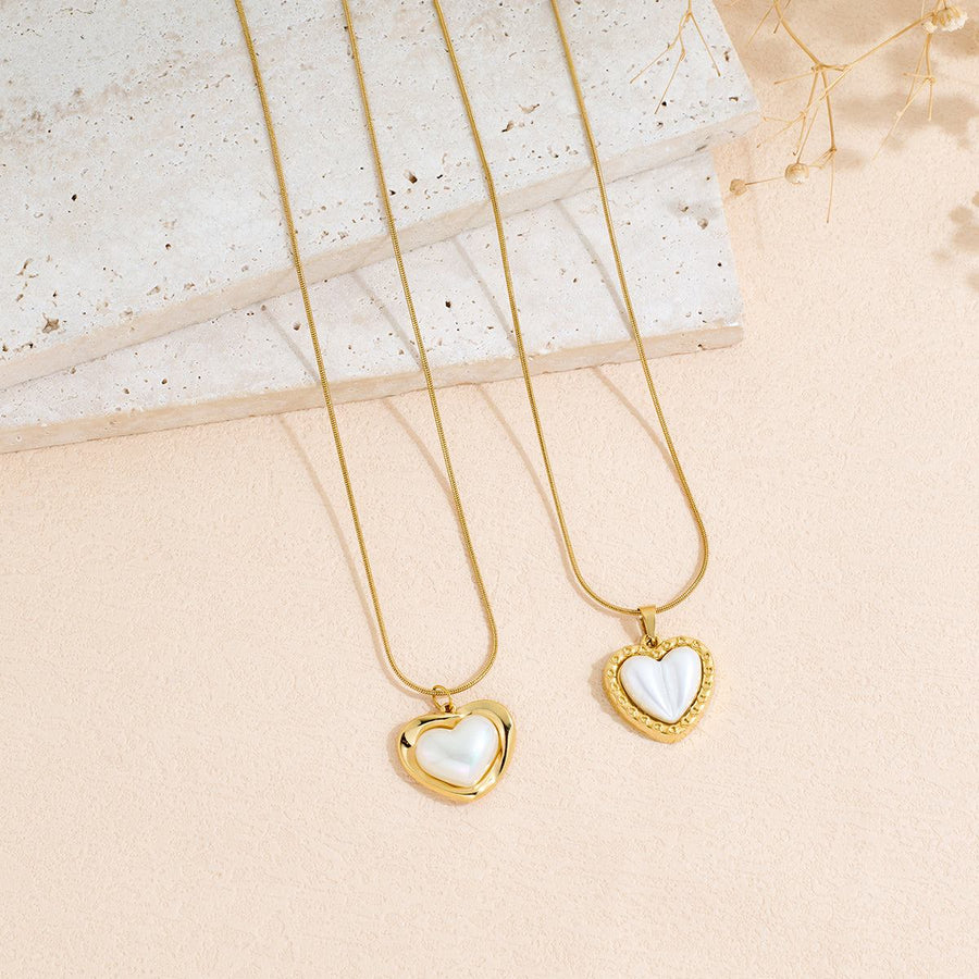 Stainless Steel heart-shaped pendant necklace with polished gold-tone chains and white heart inlays.