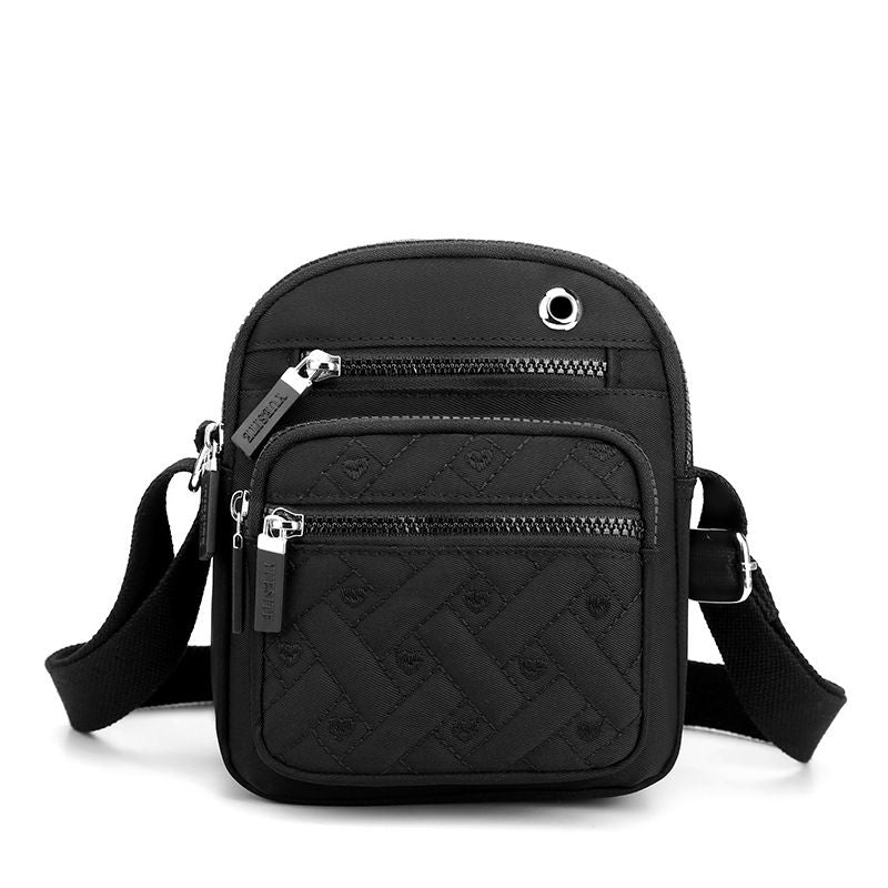 Crossbody bag in Solid Color black nylon with quilted geometric pattern, multiple zip pockets and adjustable strap