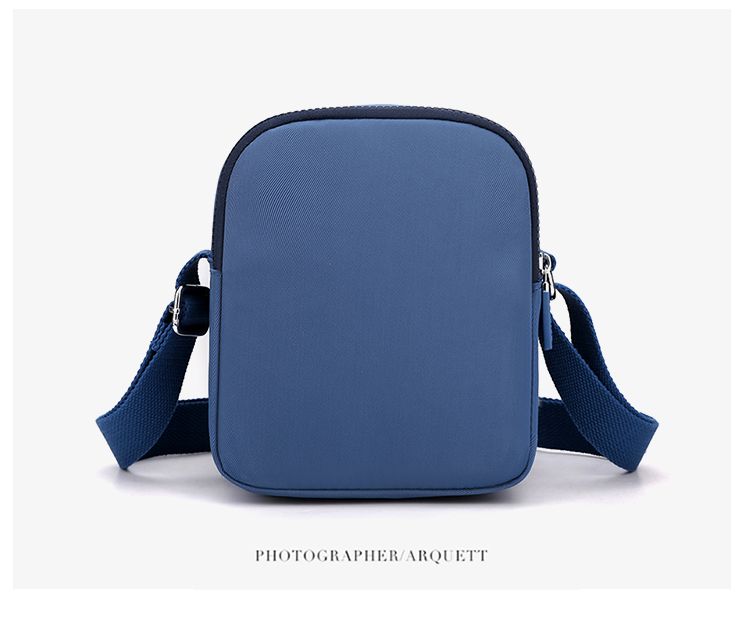 Crossbody bag in Solid Color navy blue nylon with a soft rectangular shape and adjustable shoulder strap