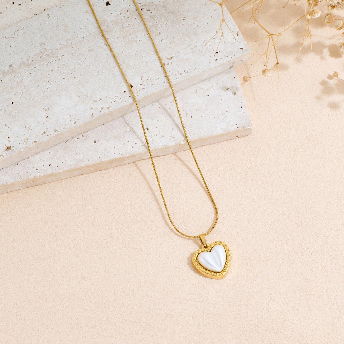 Stainless Steel gold-tone necklace with a white heart-shaped pendant and beaded heart border